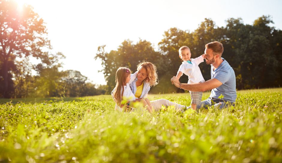 luckybusiness – stock.adobe.com Happy male and female playing with children outside